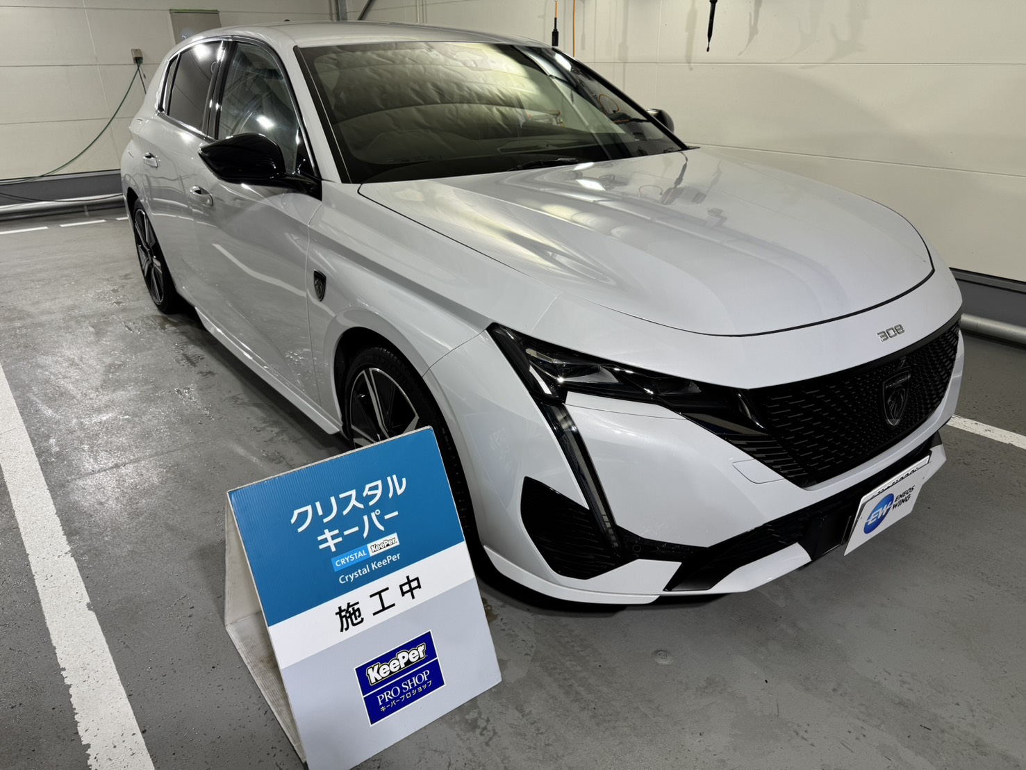 白いプジョー/308にクリスタルキーパー施工を施工した後のツヤのあるボディ
