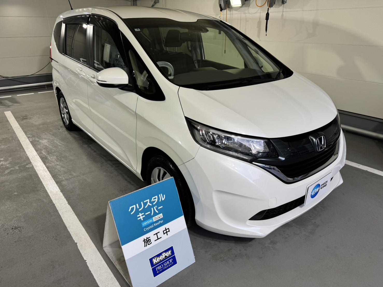 白いホンダ/フリードにクリスタルキーパーを施工した後のツヤのあるボディ