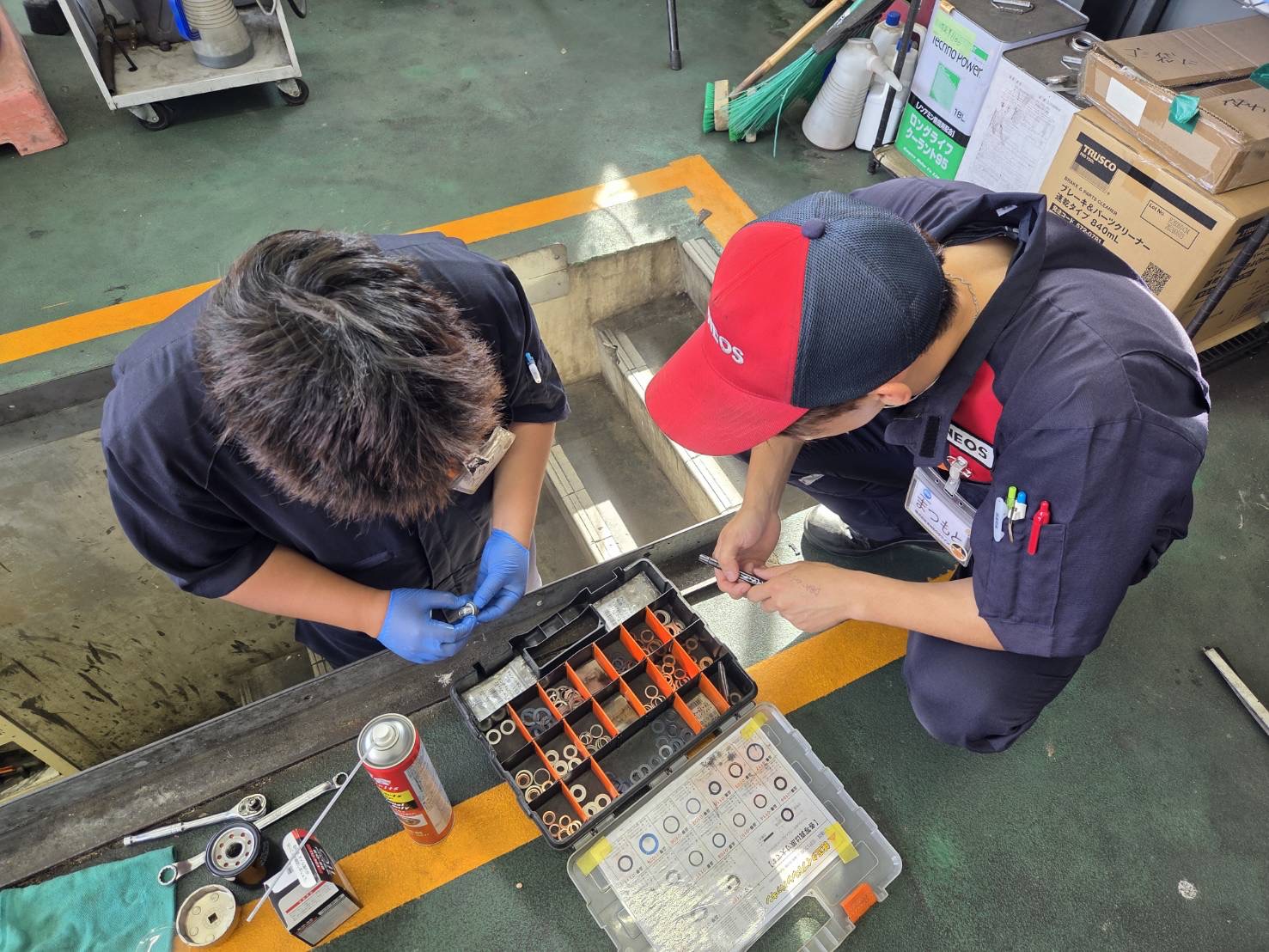 ルート19塩尻TSのスタッフがオイル交換の作業でドレンパッキンを探している様子