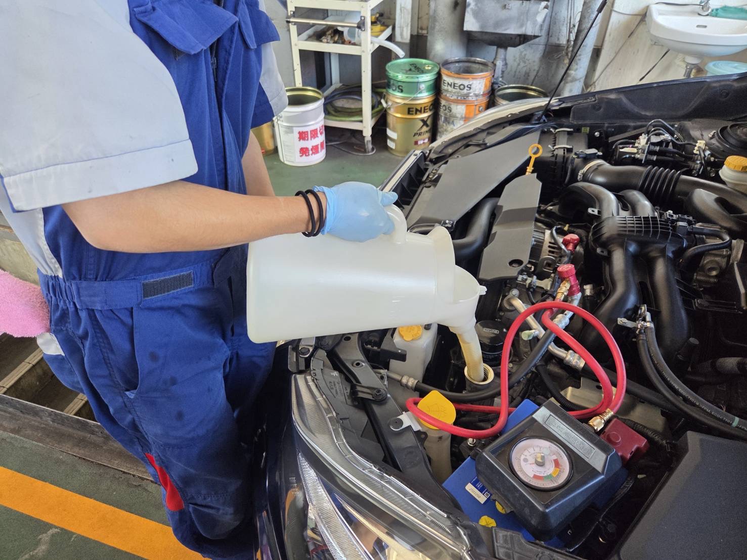 ルート19塩尻TSのスタッフがオイル交換で新しいオイルを注入している様子