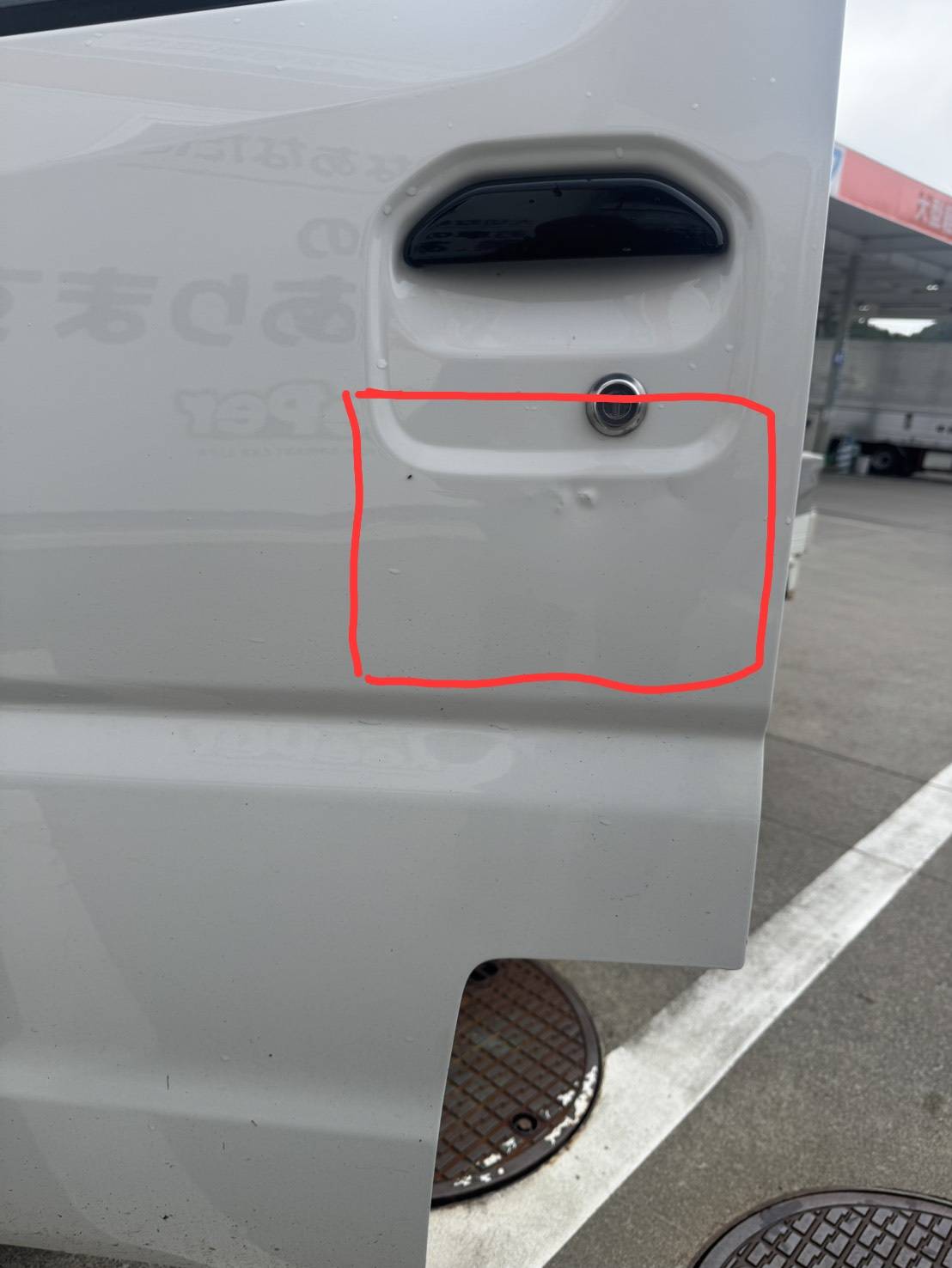白いミツビシ　ミニキャブトラックの左ドアにヘコミキズがあるキズ直し前の状態