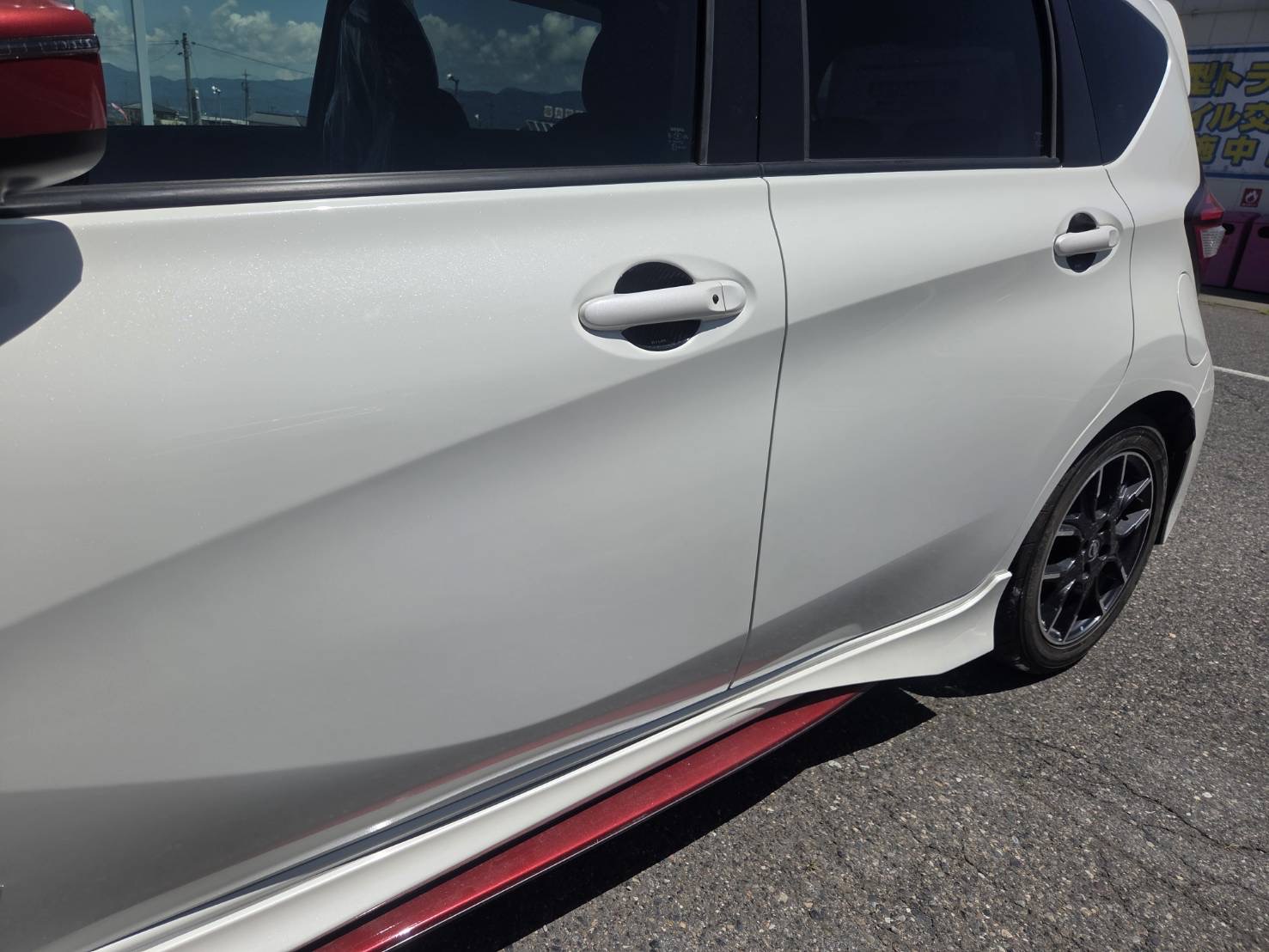白い日産　ノートNISMOの左ドア〜左リアクォーターを板金修理した施工後の状態