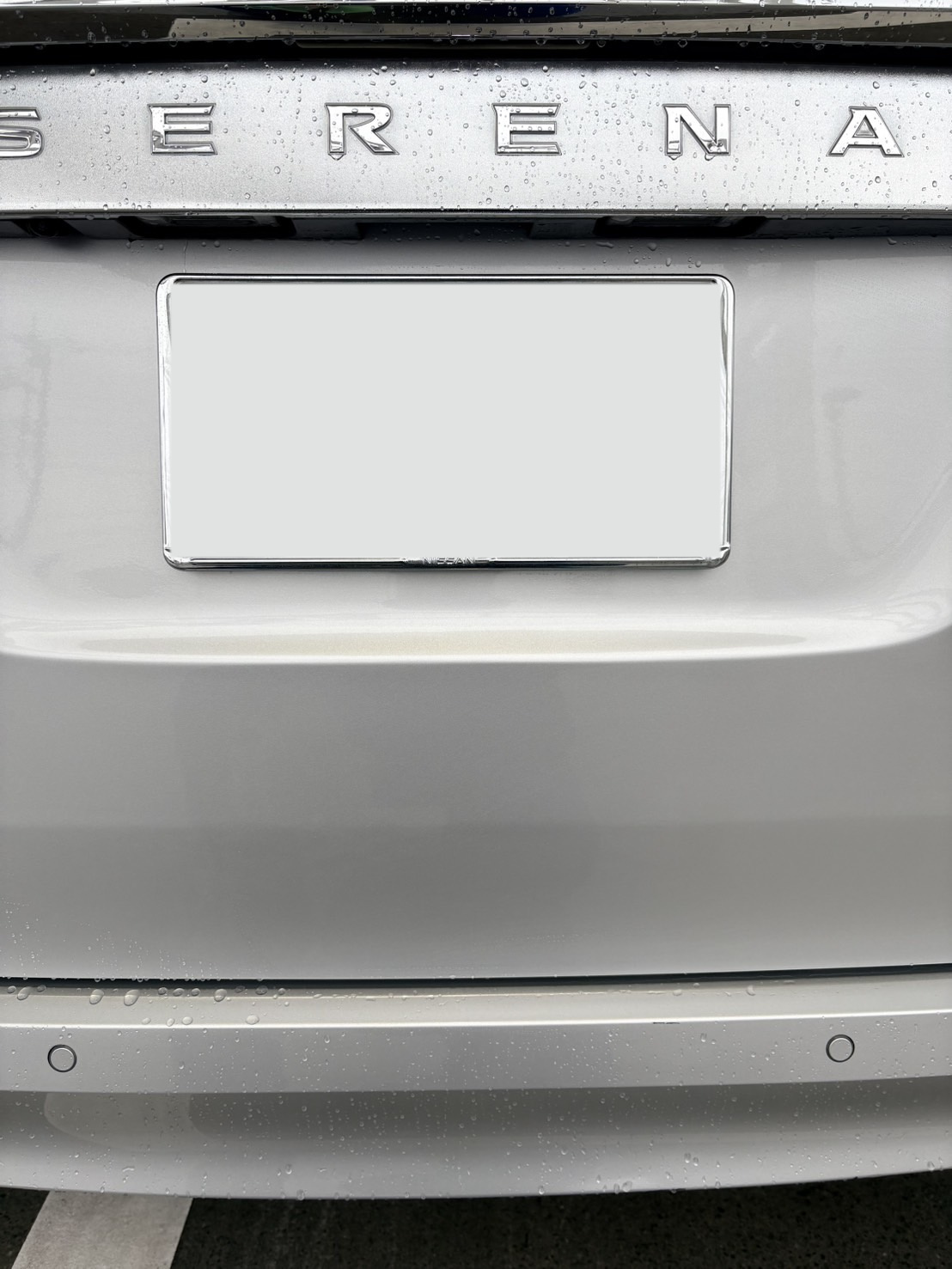 シルバーの日産　セレナのリヤナンバー近くを板金塗装で修理した施工後の状態