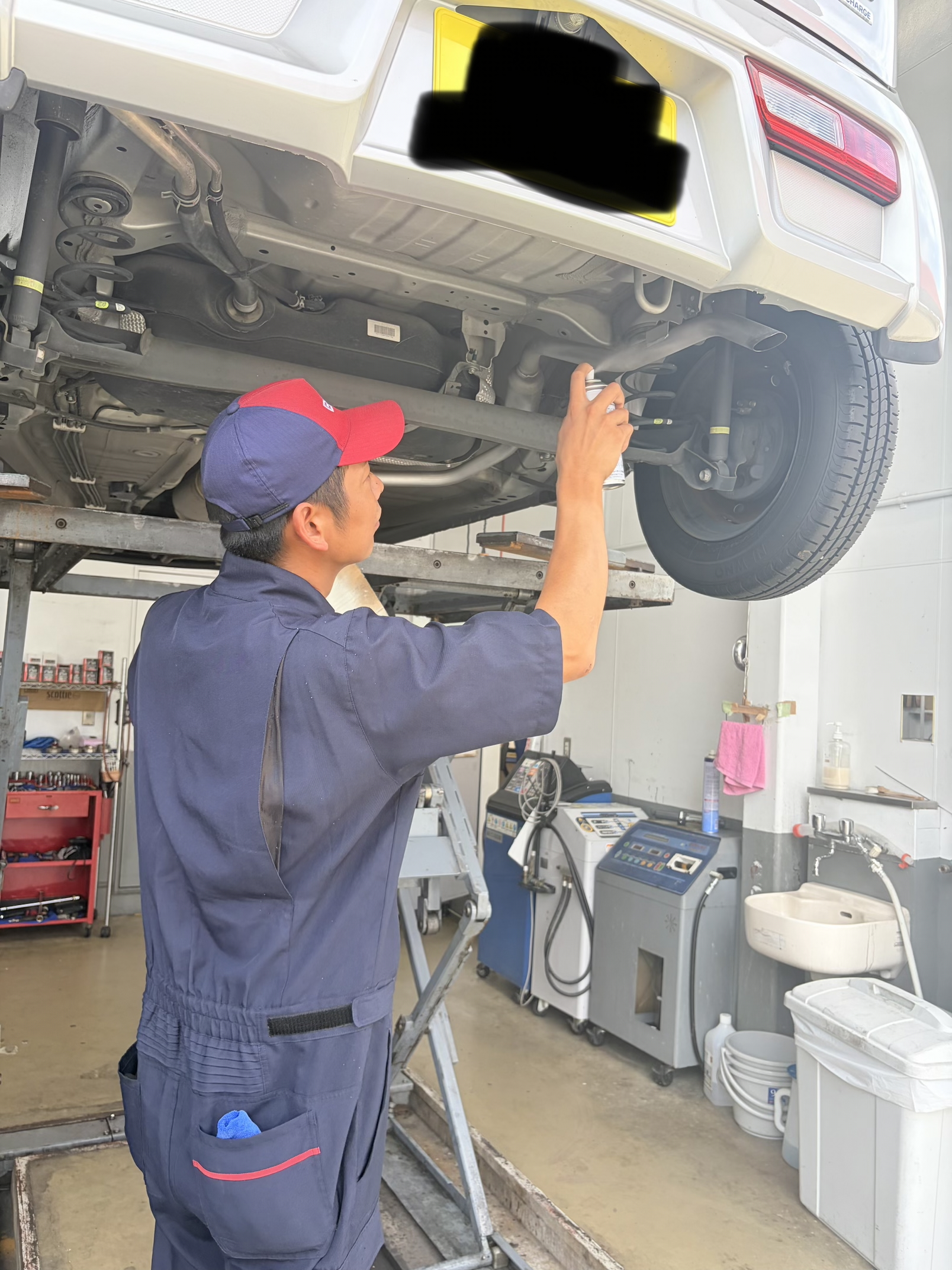 寝屋川TSのスタッフが車のマフラーコートを施工を行う様子