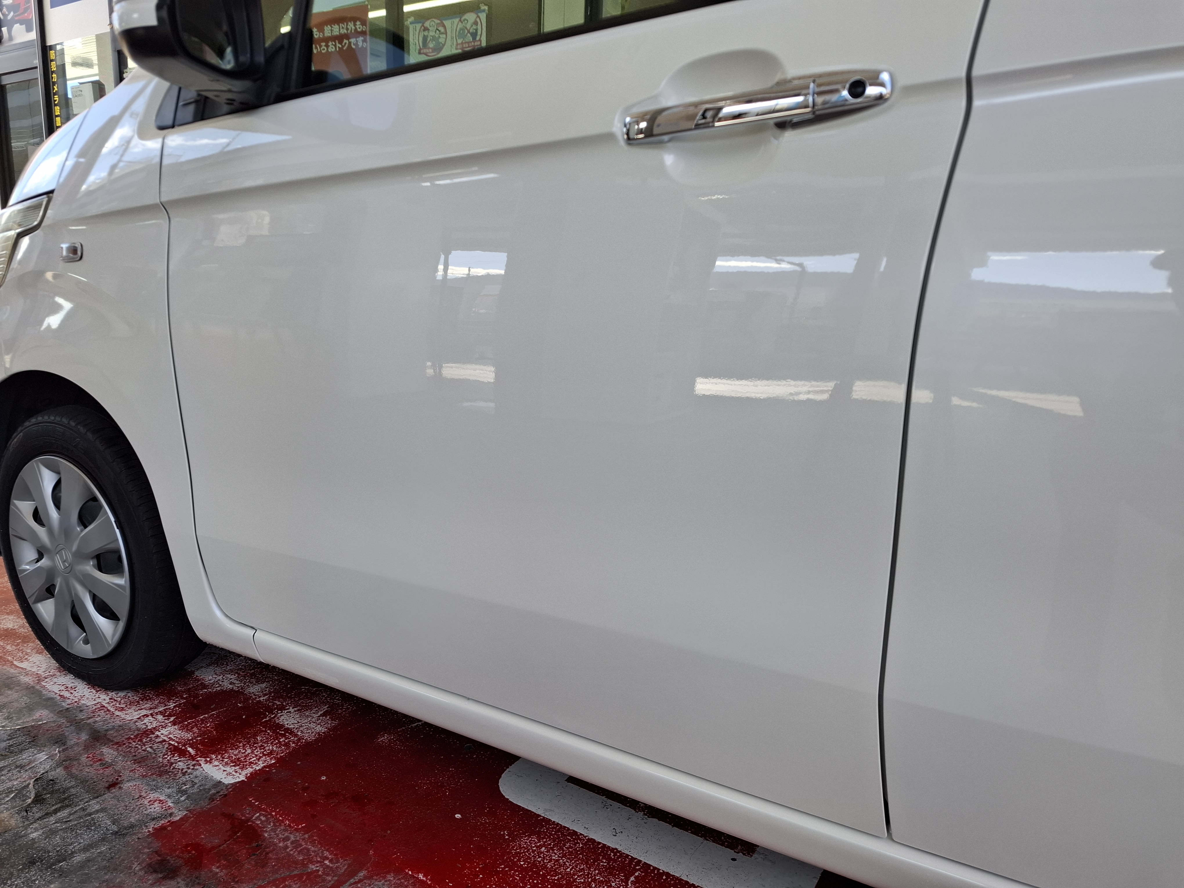 白いホンダ N-WGNの左フロントドアとサイドステップ部を板金塗装で修理した施工後の状態